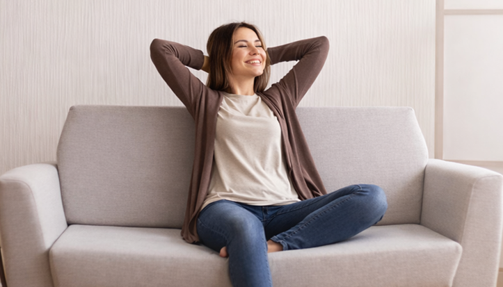Client relaxing freely on plush light green sofa
